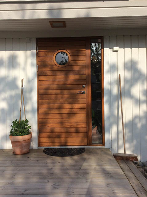 Ytterdörr i teak med runt glas och sidoljus