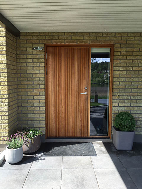 Ytterdörr i teak med stående panel och sidoljus